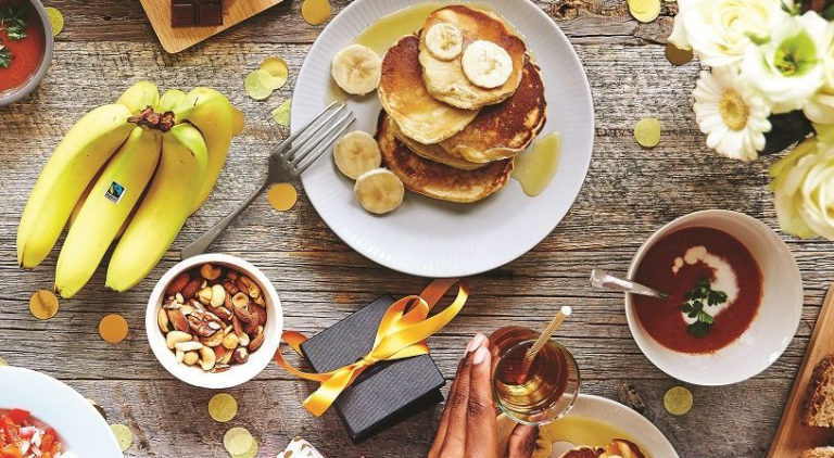 Fairtrade bananas, chocolate and other snacks on a picnic table shot from above