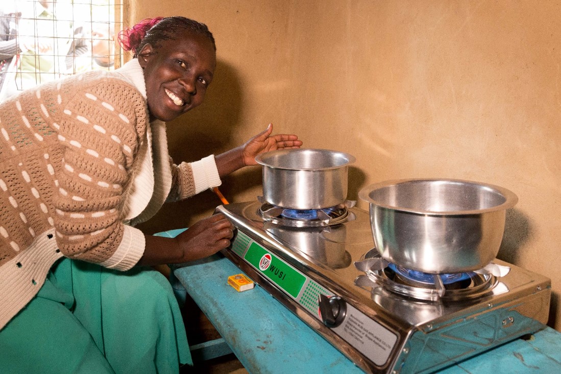 Growing Women in Coffee project - a woman in Kenya cooks on her new gas stove