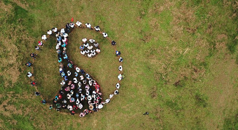 Drone image of people making the Fairtrade mark out of their bodies.
