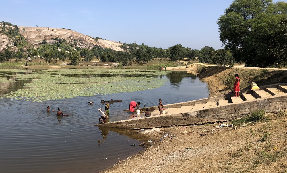 Cotton - Pratima Organic Growers co-operative members washing clothes and swimming in the river