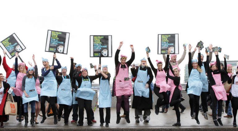 Fairtrade campaigners jumping with signs