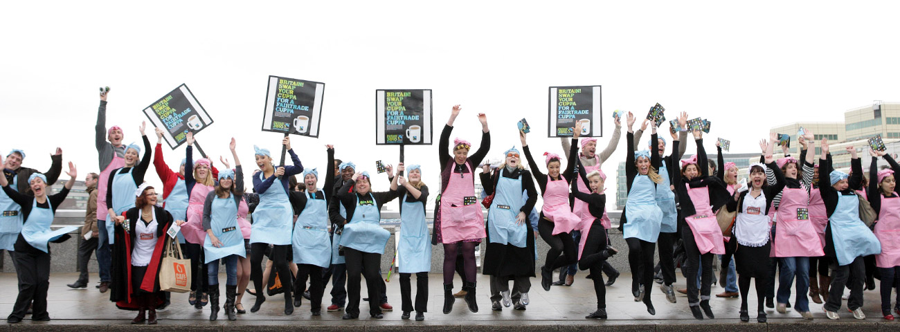Fairtrade campaigners jumping with signs