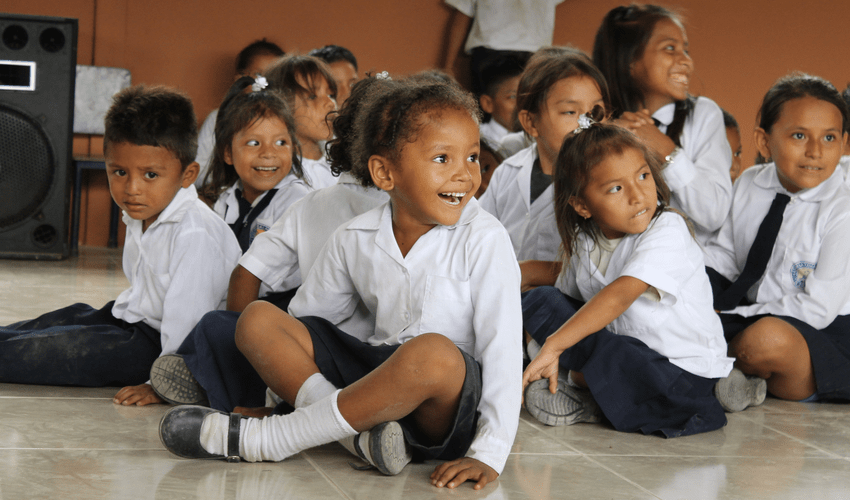 El Guabo School, school children sat in a group on the classroom floor.