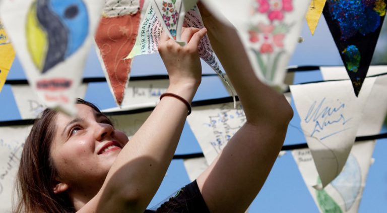 Woman hanging up Fairtrade campaigner flags