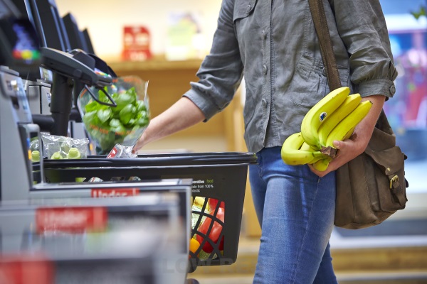 Man putting shopping in a basket including Fairtrade bananas