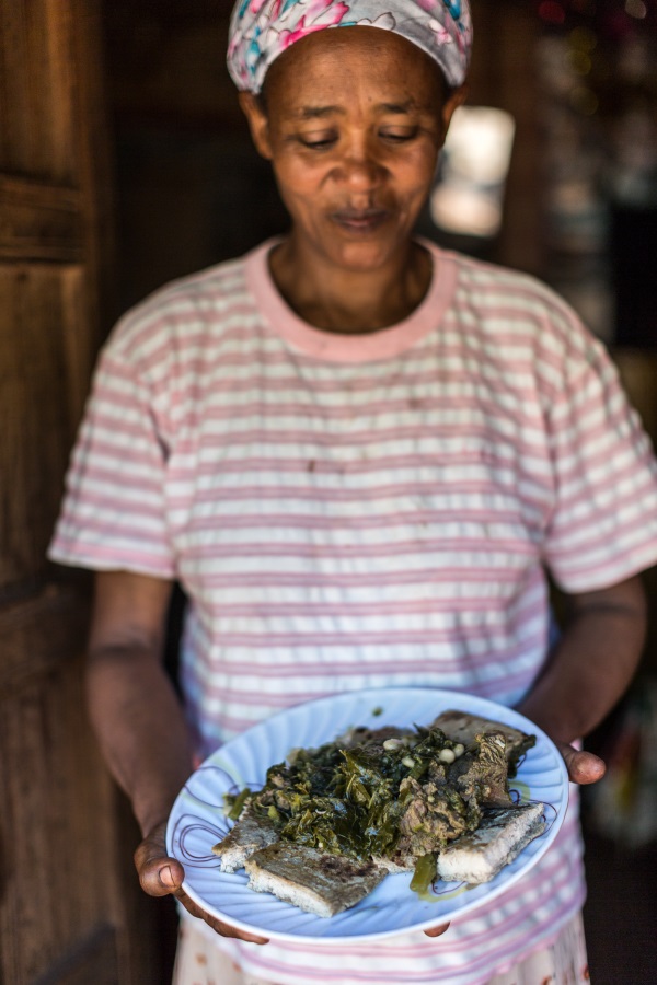 Woman holding a plate of food in Ethiopia.