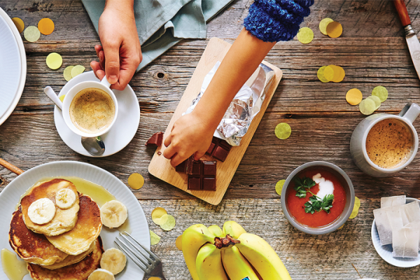 Dinner table with Fairtrade coffee, pancakes, avocado and rice cakes, Fairtrade chocolate