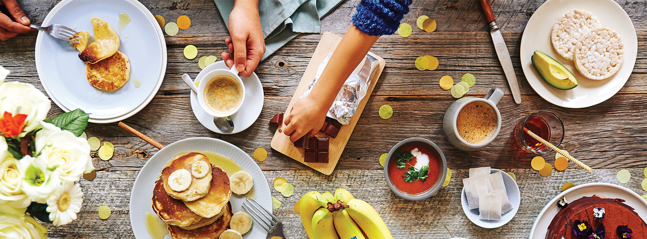 Dinner table with Fairtrade coffee, pancakes, avocado and rice cakes, Fairtrade chocolate