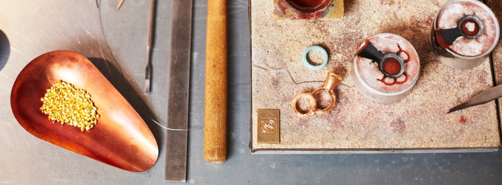 Gold jewellery workshop, tools and materials laid out on a table.