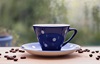 A coffee cup with coffee beans scattered around it