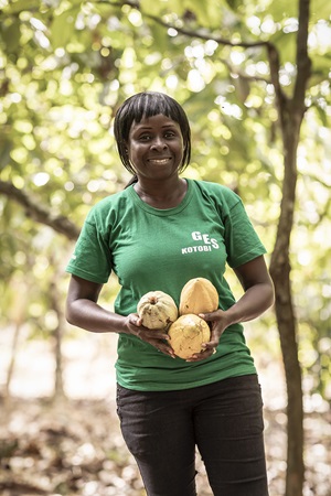 Edith holding three cocoa pods