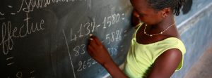A girl writes on a chalk board