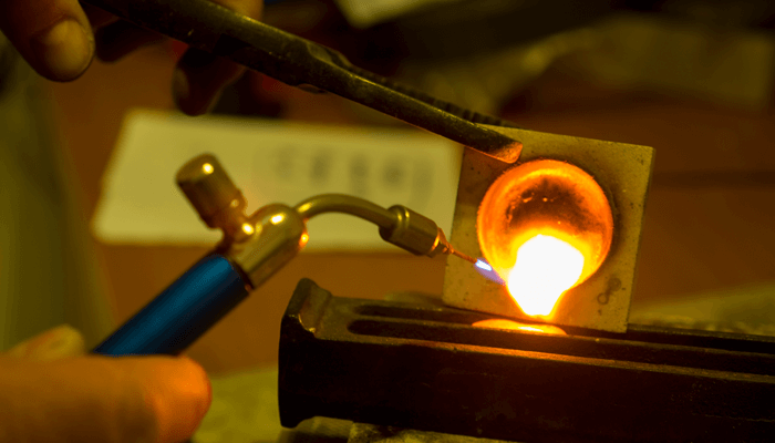 Jeweller melting Fairtrade gold in a crucible until the gold is molten and flowing nicely.