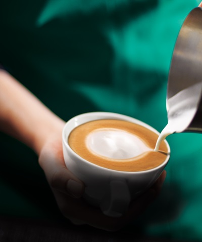 hot milk being poured into a cup of Fairtrade Espresso Roast
