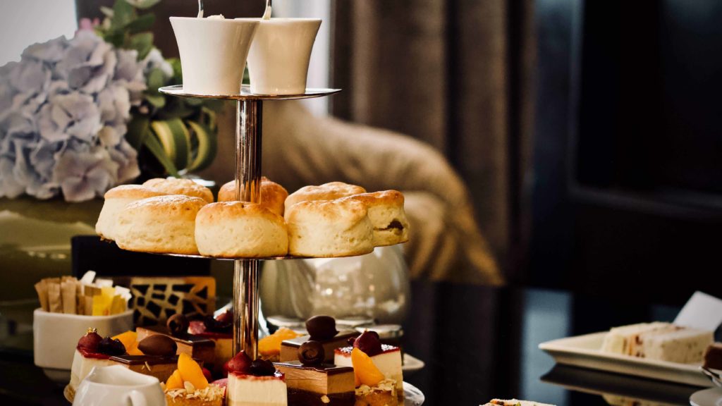 Afternoon tea spread - three tier stand with cakes, scones and tea