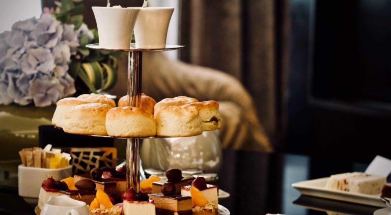 Afternoon tea spread - three tier stand with cakes, scones and tea