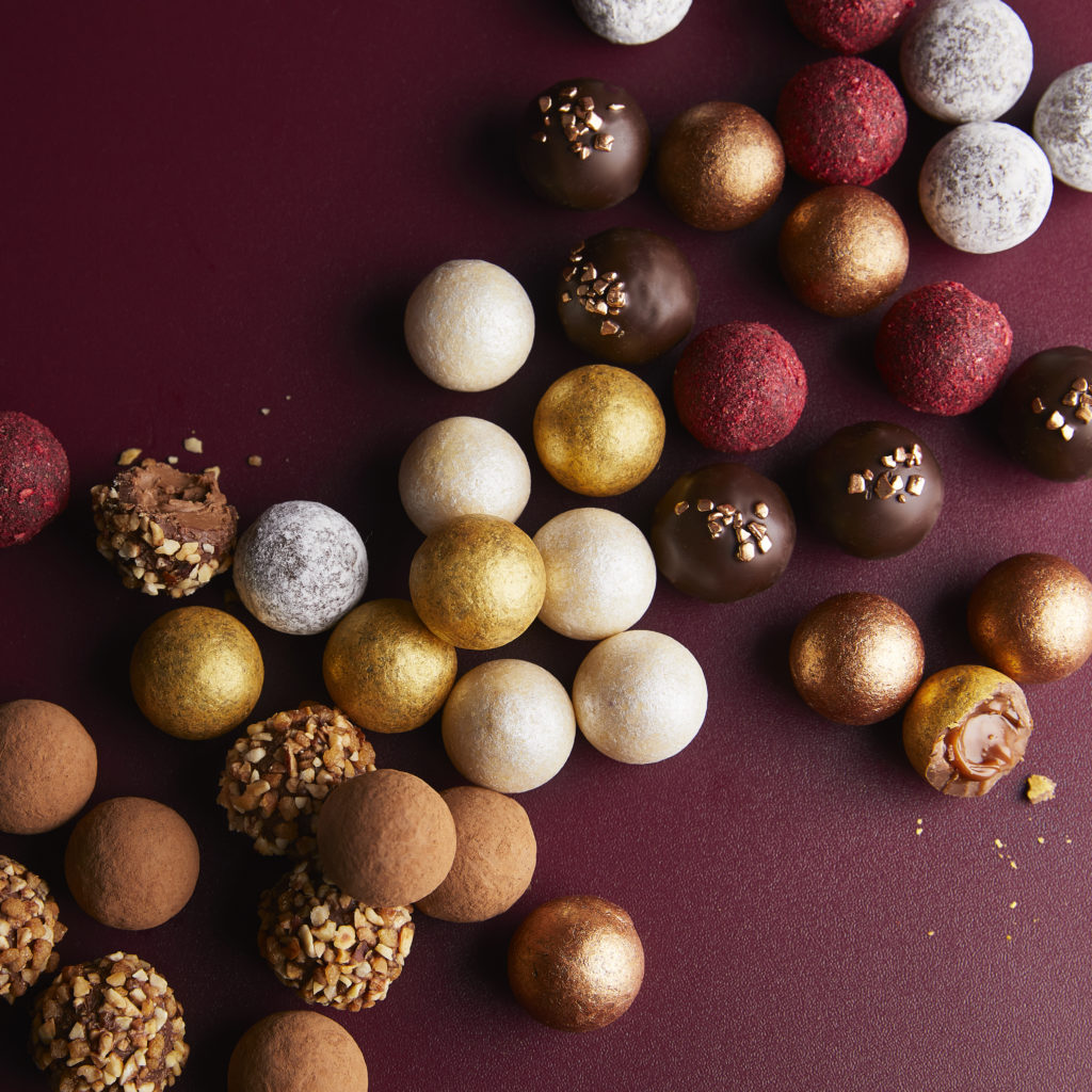 Waitrose chocolate truffles in gold, red, white and brown on a burgundy background