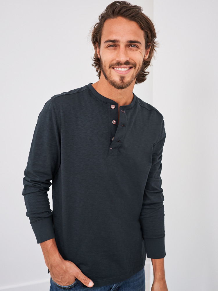 Man wearing a dark blue Fairtrade cotton top with buttons at the neck
