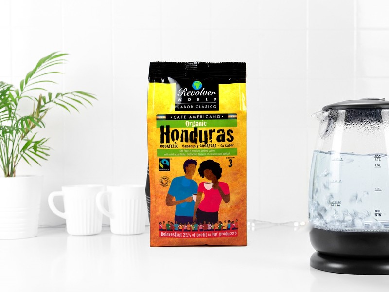 A bright and colourful packet of Revolover Honduras Fairtrade coffee, shows illustration of two peple drinking coffee on the packet