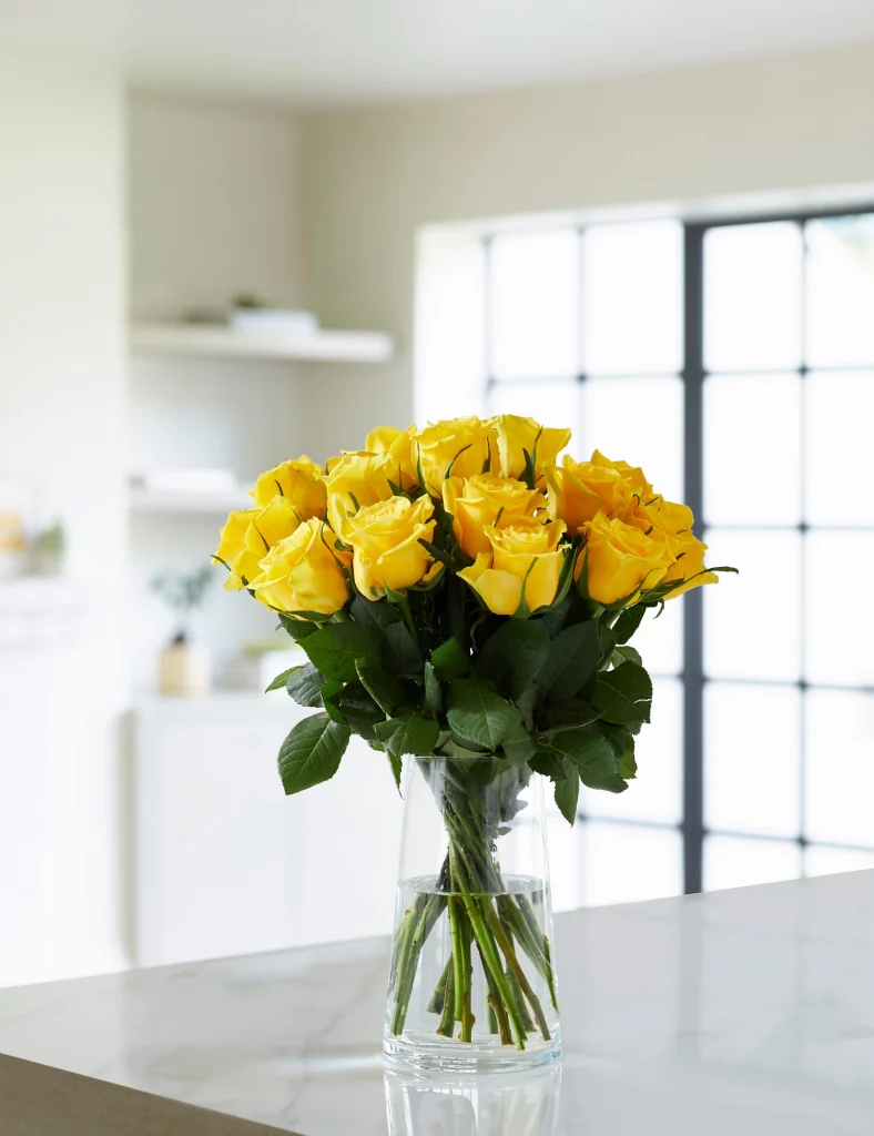 a vase filled with yellow roses