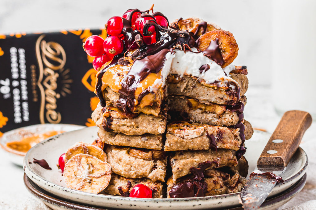 delicious looking american style chocolate pancakes on a plate with divine fairtrade chocolate and other ingredients in background
