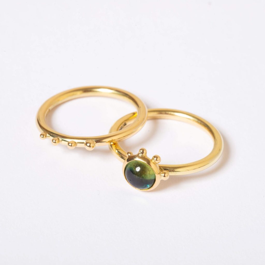 two Fairtrade gold rings one with inlaid sapphire