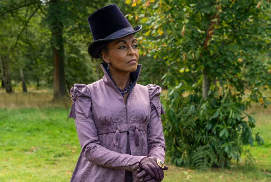 Adjoa Andoh portrait as Lady Danbury, in purple dress and top hat holding a cane