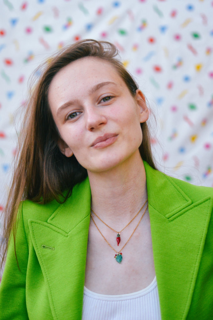 Portrait of Tolmeia Gregory, against a white background with flecks of red, pink, blue, green and yellow