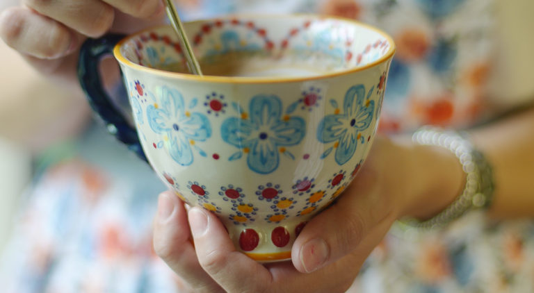 Flowery teacup containing tea.