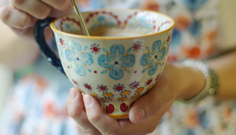 Flowery teacup containing tea.