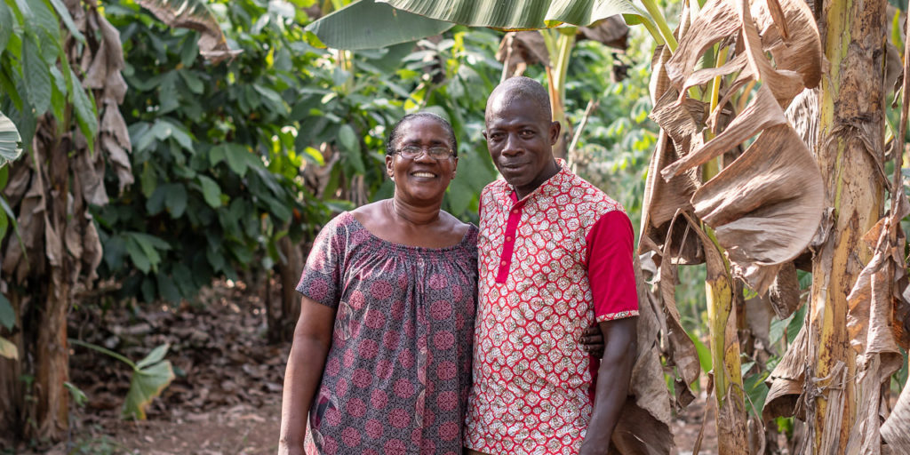 Amah Kouao poses with her friend Amoakon Kpanguin, one of the men to attend the WSOL from Anniassue. They stand in a cocoa farm.