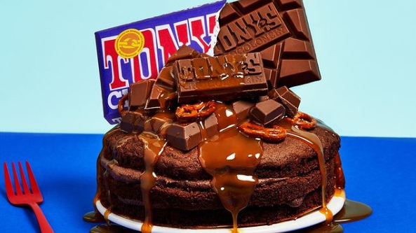 Decadent Fairtrade chocolate cake with dripping toffee and a bar of Tony's Chocolonely on top