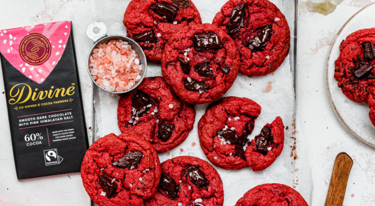 red cookies with chocolate chunks in, next to a bar of Divine chocolate