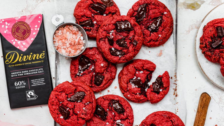 red cookies with chocolate chunks in, next to a bar of Divine chocolate