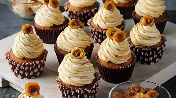 a plate of cupcakes with cream topping and caremlised banana slices