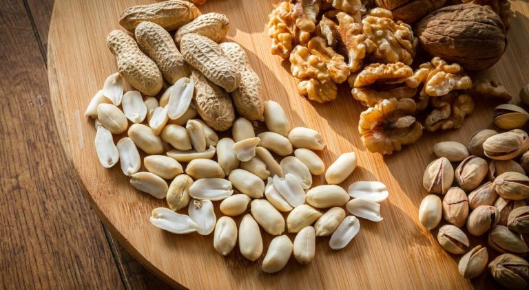 selection of peanuts, walnuts, cashew and almonds on a wooden board
