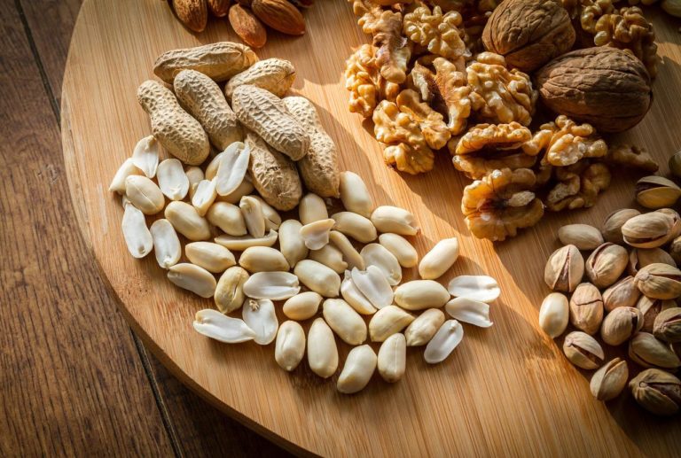 selection of peanuts, walnuts, cashew and almonds on a wooden board