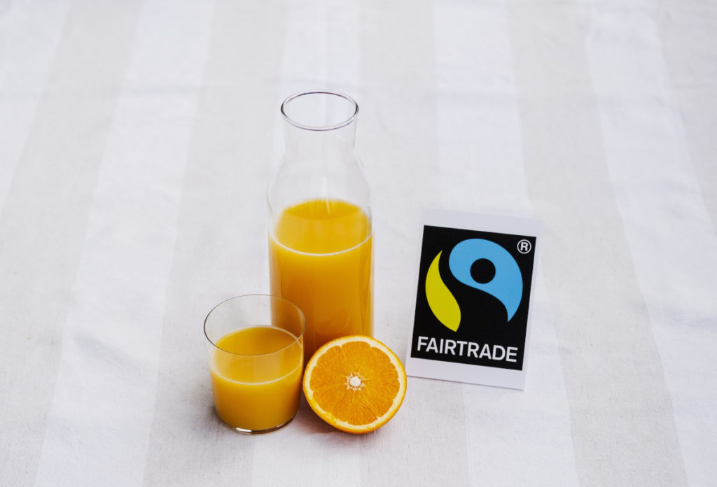 Fairtrade orange juice in a glass and cut orange.