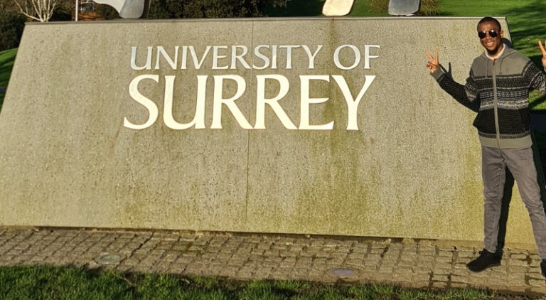 Person standing outside University of Surrey entrance